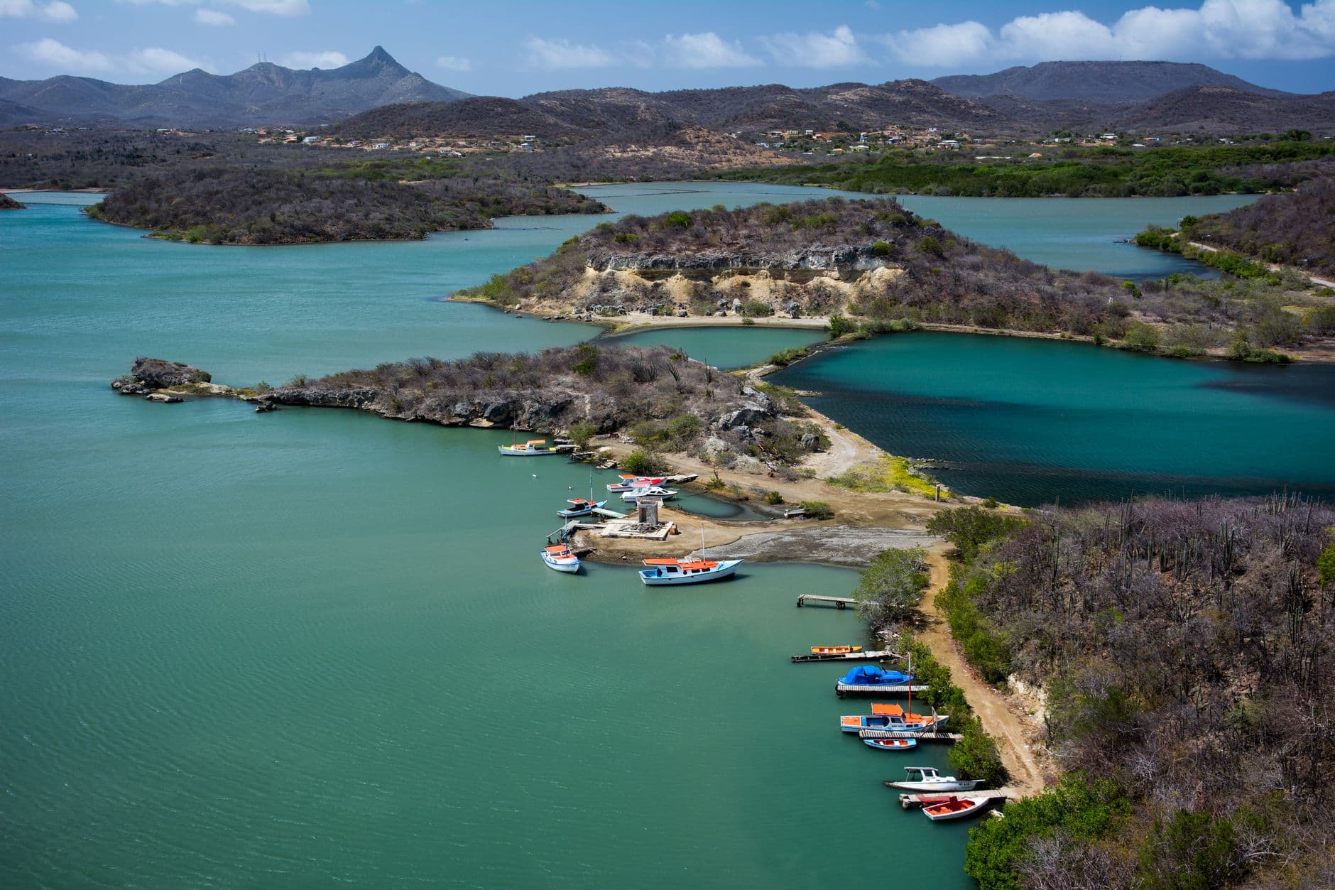 Baai met vissersboten en de heuvels van Curaçao op de achtergrond
